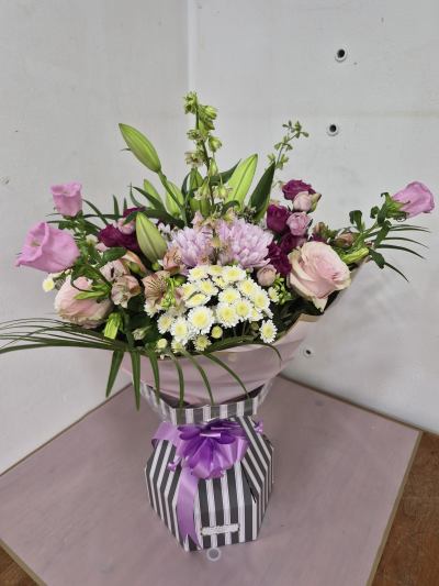 Pink Meadows - Beautiful arranged flowers in links creams and cerise colours. Photo is a large size . 
Lillie's, roses lisiantus, campulas, carnations ,chrysants, limonium , alstromeria, larkspur, Bloom chrysants, phoenix leaves